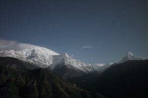 A snowy mountain tops at night